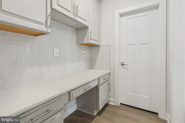 121 Mountain Path Ln, Stafford, VA 22554 - kitchen featuring wood finished floors, backsplash, light stone countertops, and white cabinets