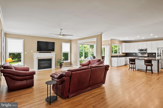 10604 Sourwood Ct, Laurel, MD 20723 - living room with ornamental molding, light wood-style floors, ceiling fan, a glass covered fireplace, and recessed lighting