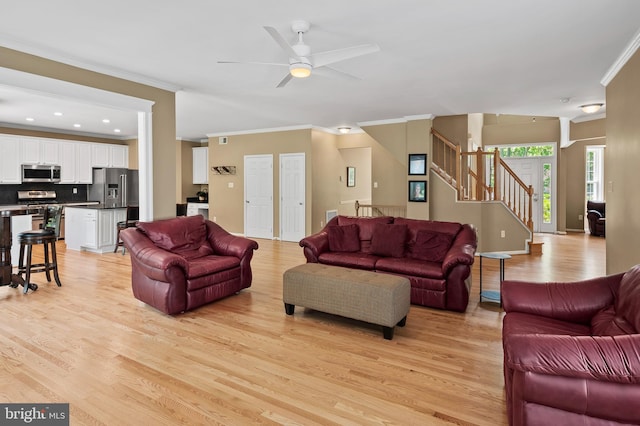 10604 Sourwood Ct, Laurel, MD 20723 - living room with crown molding, light wood-style floors, ceiling fan, stairs, and recessed lighting