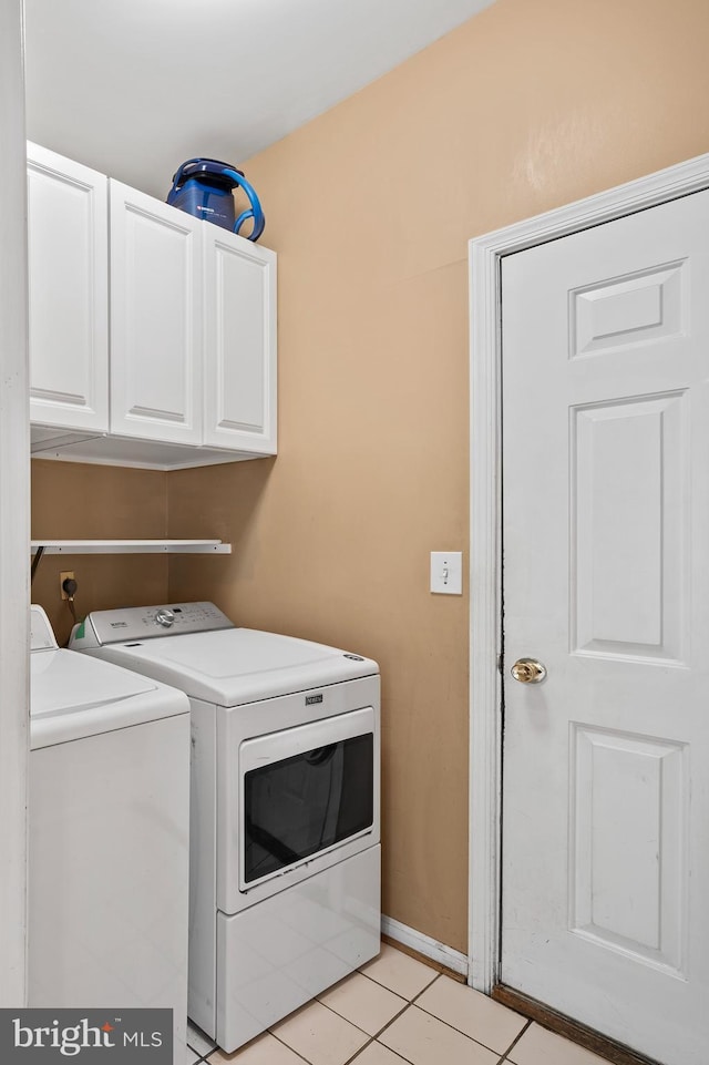 10604 Sourwood Ct, Laurel, MD 20723 - laundry area featuring washing machine and dryer, cabinet space, and light tile patterned flooring