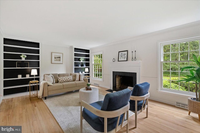 33 Duffield Pl, Princeton, NJ 08540 - living area with crown molding, light wood finished floors, a brick fireplace, and built in features