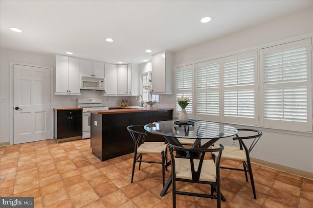 33 Duffield Pl, Princeton, NJ 08540 - kitchen featuring white appliances, a sink, a peninsula, white cabinetry, and baseboards
