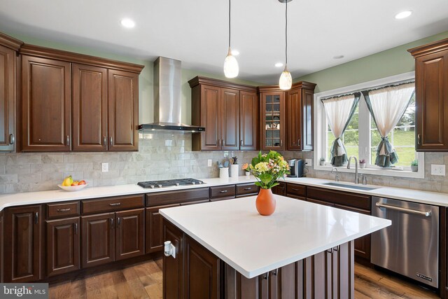 213 Athena Ct, Wilmington, DE 19808 - kitchen featuring stainless steel appliances, wall chimney exhaust hood, light countertops, a sink, and dark wood-style floors