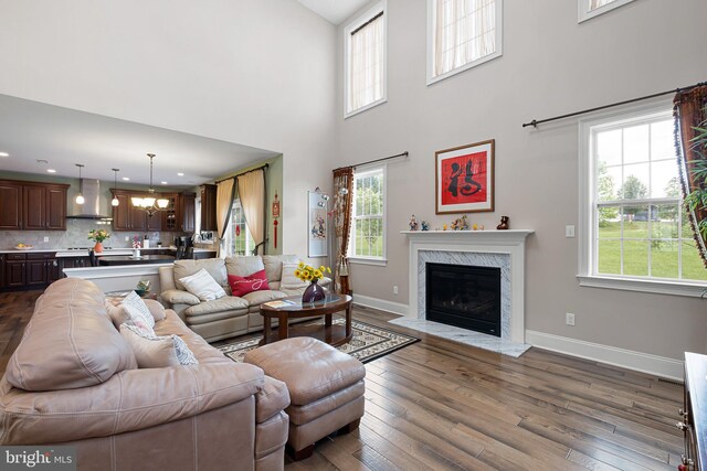 213 Athena Ct, Wilmington, DE 19808 - living area with plenty of natural light, a fireplace, baseboards, a chandelier, and a high ceiling