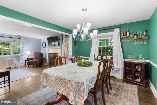 625 Lindley Rd, Glenside, PA 19038 - dining area featuring a chandelier, wood finished floors, a brick fireplace, radiator heating unit, and baseboards