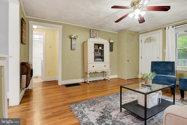 1768 Glen Cove Rd, Darlington, MD 21034 - living area featuring heating unit, light wood-style floors, ceiling fan, baseboards, and crown molding