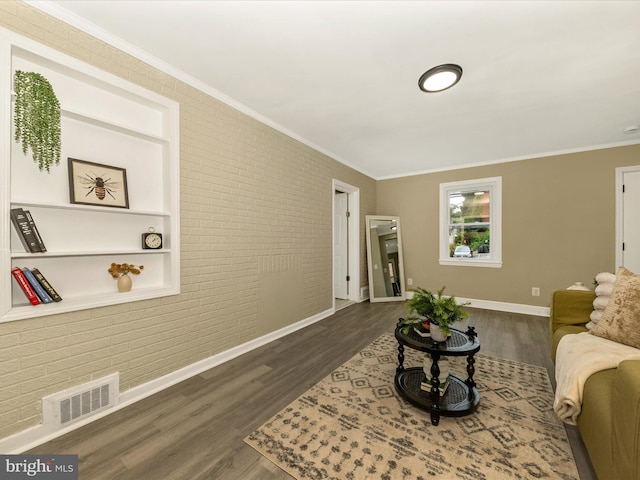 8709 Bradford Rd, Silver Spring, MD 20901 - living room with brick wall, crown molding, baseboards, dark wood-style flooring, and built in features
