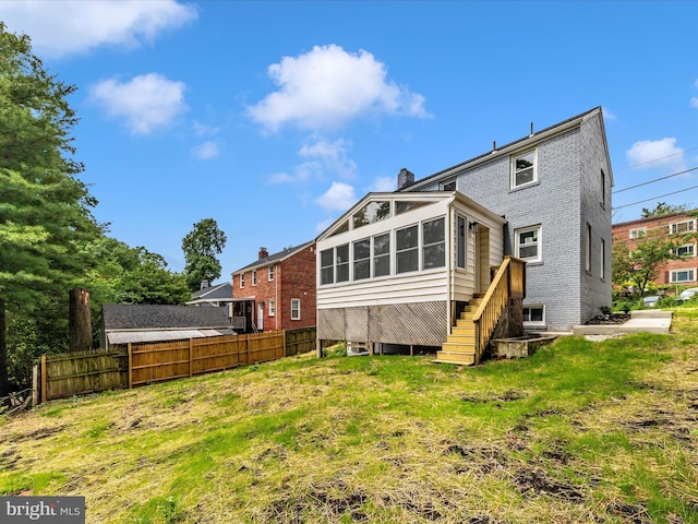8709 Bradford Rd, Silver Spring, MD 20901 - rear view of property featuring a sunroom, brick siding, a chimney, and stairs