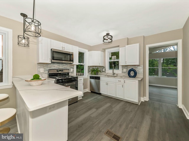 8709 Bradford Rd, Silver Spring, MD 20901 - kitchen featuring stainless steel appliances, a sink, tasteful backsplash, and white cabinets