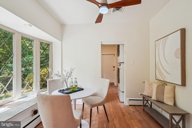 9101 Sligo Creek Pkwy, Silver Spring, MD 20901 - dining space with stacked washer and clothes dryer, light wood finished floors, ceiling fan, and baseboard heating