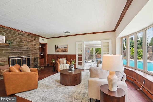 9101 Sligo Creek Pkwy, Silver Spring, MD 20901 - living room featuring wood-type flooring, healthy amount of natural light, a large fireplace, a wainscoted wall, and crown molding
