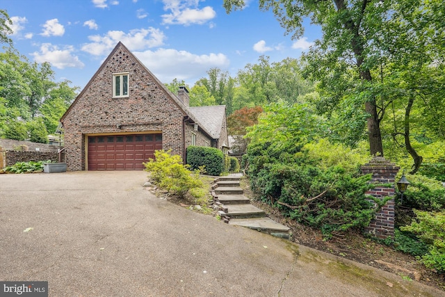 9101 Sligo Creek Pkwy, Silver Spring, MD 20901 - tudor-style house featuring driveway, brick siding, a garage, and a chimney