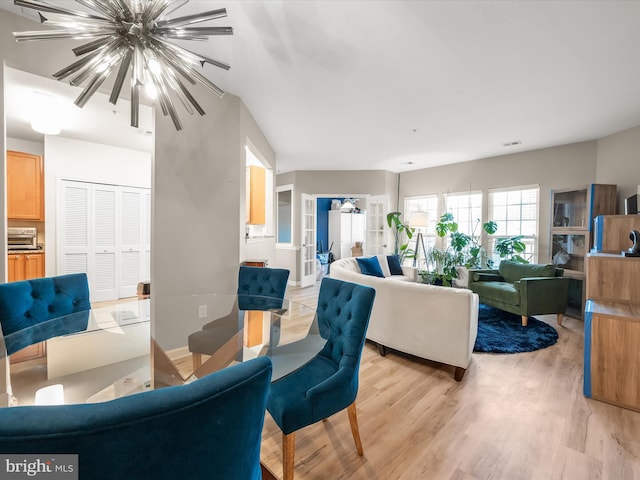5307 Wyndholme Cir Unit 302, Baltimore, MD 21229 - living room with a chandelier and light wood-style floors