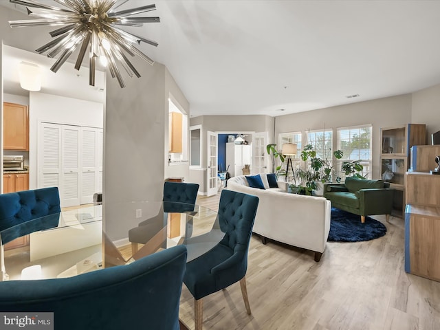 5307 Wyndholme Cir Unit 302, Baltimore, MD 21229 - living area with a chandelier and light wood-style flooring