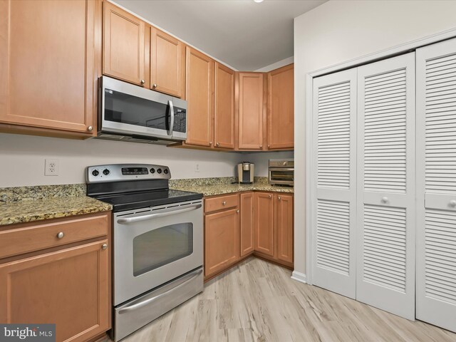 5307 Wyndholme Cir Unit 302, Baltimore, MD 21229 - kitchen with stainless steel appliances, light wood-style flooring, and light stone counters