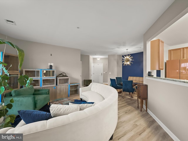 5307 Wyndholme Cir Unit 302, Baltimore, MD 21229 - living area featuring a chandelier, light wood-type flooring, and baseboards
