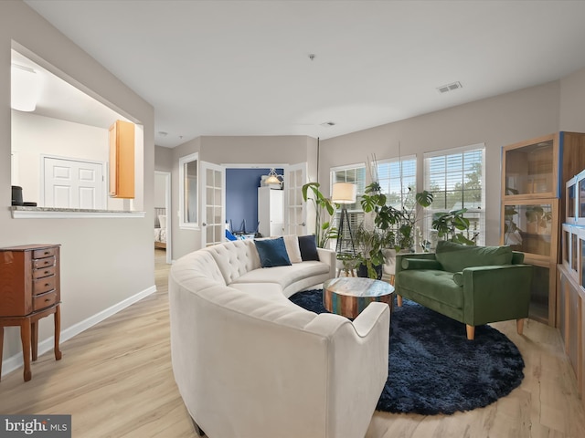 5307 Wyndholme Cir Unit 302, Baltimore, MD 21229 - living room with french doors, light wood-style flooring, and baseboards