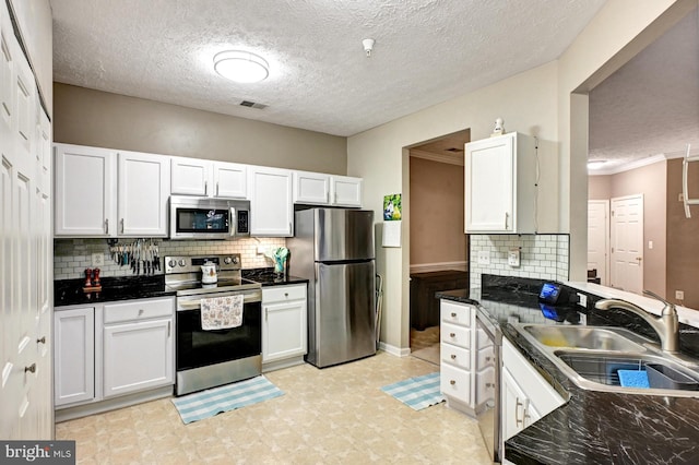 9615 Haven Farm Rd Unit 9615G, Perry Hall, MD 21128 - kitchen featuring appliances with stainless steel finishes, white cabinets, backsplash, light flooring, and a textured ceiling