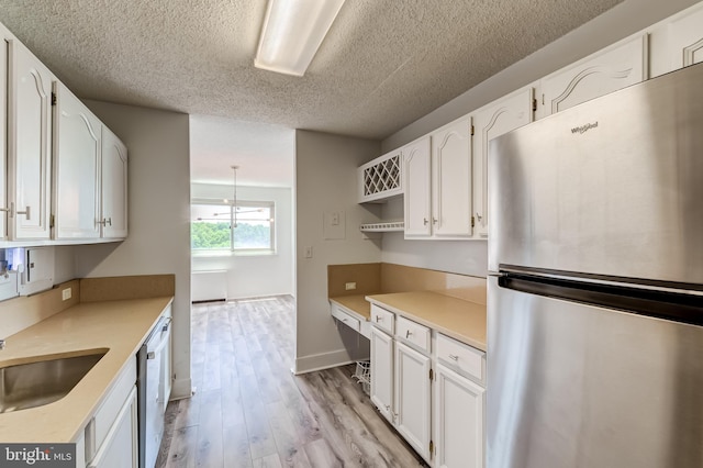 1225 Martha Custis Dr Unit 1210, Alexandria, VA 22302 - kitchen featuring freestanding refrigerator, dishwashing machine, light wood-type flooring, white cabinetry, and a textured ceiling