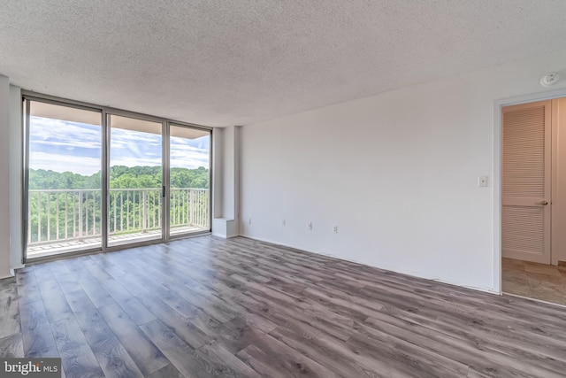 1225 Martha Custis Dr Unit 1210, Alexandria, VA 22302 - unfurnished room with a wall of windows, a textured ceiling, wood finished floors, and a smoke detector