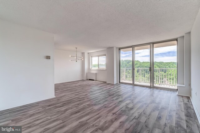 1225 Martha Custis Dr Unit 1210, Alexandria, VA 22302 - spare room with a textured ceiling, wood finished floors, a chandelier, and a wall of windows