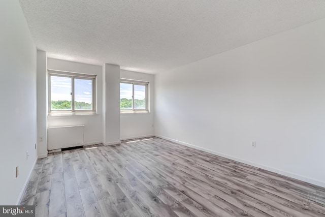 1225 Martha Custis Dr Unit 1210, Alexandria, VA 22302 - unfurnished room with radiator, wood finished floors, a textured ceiling, and baseboards
