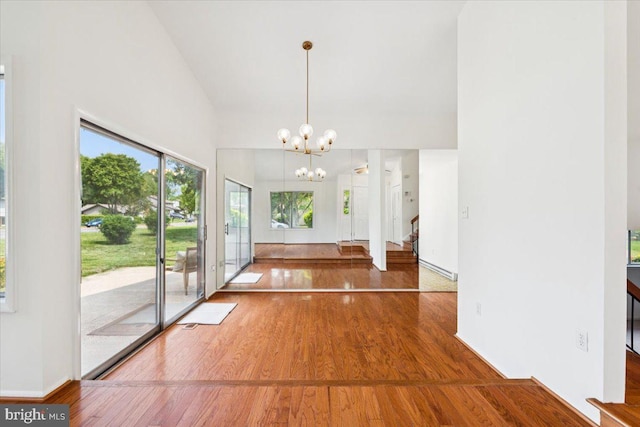 167 S Fox Rd, Sterling, VA 20164 - unfurnished dining area featuring high vaulted ceiling, wood finished floors, stairway, a chandelier, and baseboards