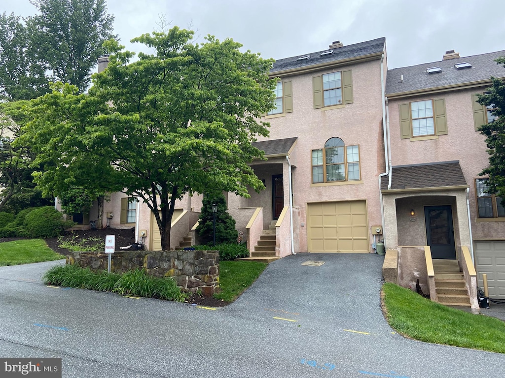 3205 Stoneham Dr, West Chester, PA 19382 - view of property with asphalt driveway, an attached garage, and stucco siding