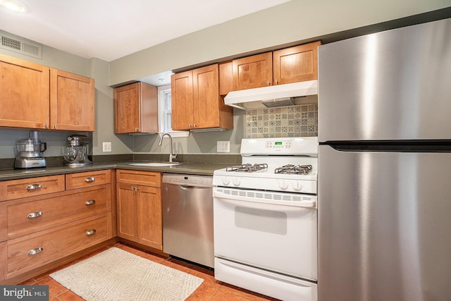 126 Ford St, Conshohocken, PA 19428 - kitchen featuring appliances with stainless steel finishes, a sink, under cabinet range hood, dark countertops, and brown cabinets