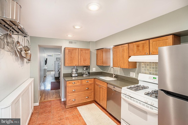 126 Ford St, Conshohocken, PA 19428 - kitchen with appliances with stainless steel finishes, under cabinet range hood, a sink, dark countertops, and recessed lighting