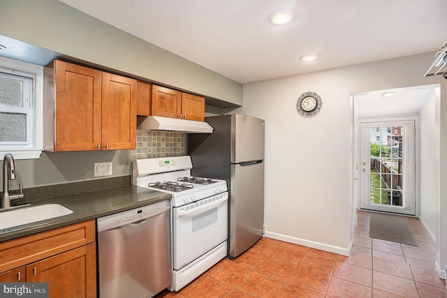 126 Ford St, Conshohocken, PA 19428 - kitchen with stainless steel appliances, under cabinet range hood, a sink, dark countertops, and brown cabinets