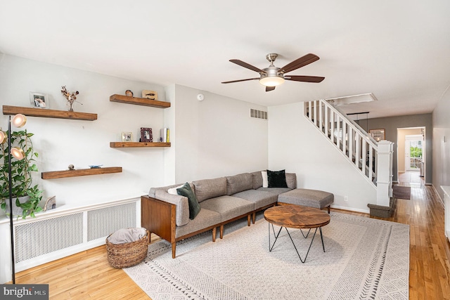 126 Ford St, Conshohocken, PA 19428 - living area featuring radiator heating unit, stairway, wood finished floors, a ceiling fan, and baseboards
