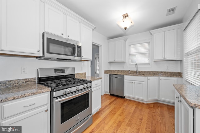 6 E Hamilton Ave, Silver Spring, MD 20901 - kitchen with stainless steel appliances, a sink, white cabinetry, light wood-type flooring, and light stone counters