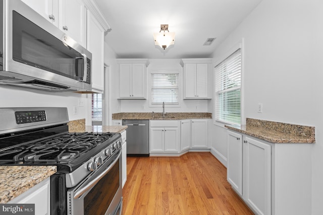 6 E Hamilton Ave, Silver Spring, MD 20901 - kitchen featuring stainless steel appliances, a sink, white cabinetry, light wood-style flooring, and light stone countertops