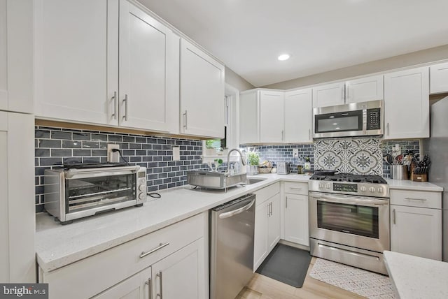11008 Madison St, Kensington, MD 20895 - kitchen featuring appliances with stainless steel finishes, white cabinets, tasteful backsplash, and recessed lighting
