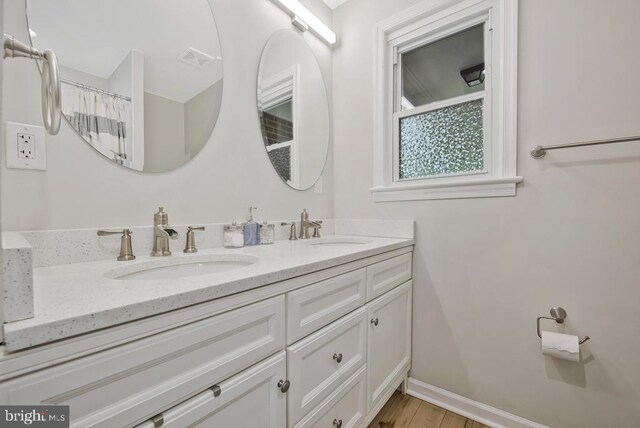 11008 Madison St, Kensington, MD 20895 - full bathroom featuring double vanity, baseboards, and wood finished floors