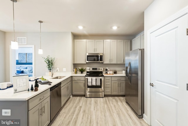 406-203 Bold Ruler Ct, Havre De Grace, MD 21078 - kitchen with appliances with stainless steel finishes, gray cabinetry, a sink, light wood-style flooring, and a peninsula