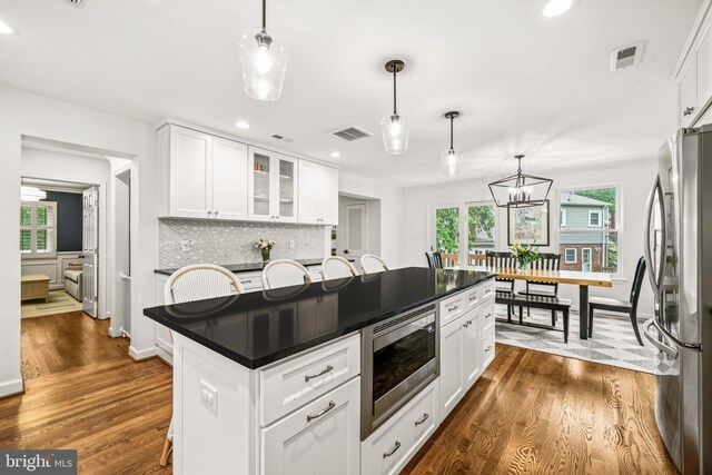 3311 Cameron Mills Rd, Alexandria, VA 22302 - kitchen with stainless steel appliances, dark countertops, dark wood-style flooring, white cabinets, and recessed lighting