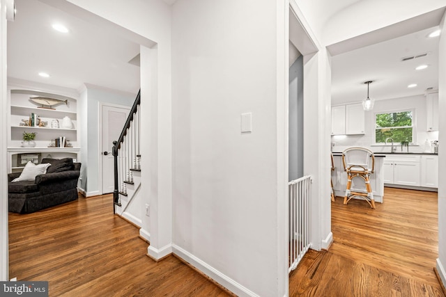 3311 Cameron Mills Rd, Alexandria, VA 22302 - hall featuring light wood-style floors, a sink, recessed lighting, baseboards, and built in shelves