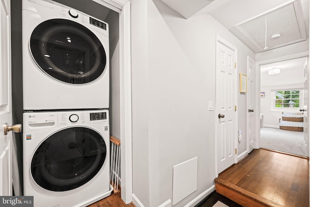 3311 Cameron Mills Rd, Alexandria, VA 22302 - laundry room featuring attic access, stacked washer / drying machine, wood finished floors, and baseboards
