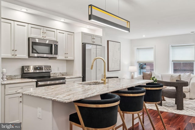 2203 Race St, Philadelphia, PA 19103 - kitchen with stainless steel appliances, a sink, dark wood finished floors, a kitchen bar, and recessed lighting