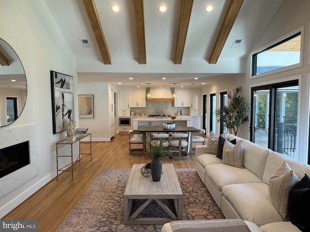 1324 Kingston Ave, Alexandria, VA 22302 - living area with light wood-style floors, beam ceiling, baseboards, high vaulted ceiling, and a premium fireplace