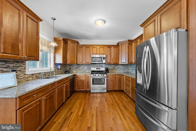 143 Oak St, Bridgewater, NJ 08807 - kitchen with appliances with stainless steel finishes, brown cabinets, a sink, light wood finished floors, and decorative backsplash