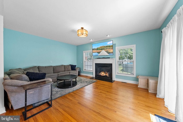 143 Oak St, Bridgewater, NJ 08807 - living room with light wood-style floors, a glass covered fireplace, and baseboards