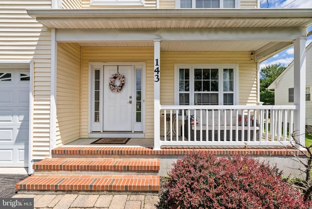 143 Oak St, Bridgewater, NJ 08807 - doorway to property featuring covered porch and an attached garage