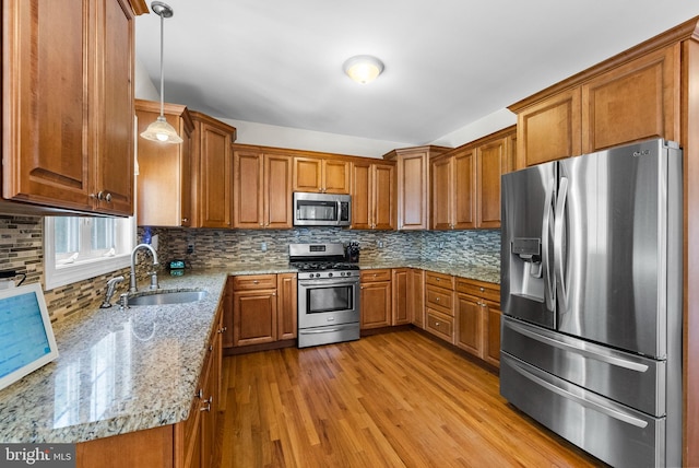 143 Oak St, Bridgewater, NJ 08807 - kitchen with stainless steel appliances, a sink, brown cabinetry, and light wood finished floors