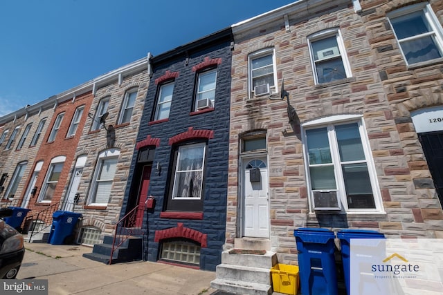 1210 Sargeant St, Baltimore, MD 21223 - view of property featuring stone siding, entry steps, and cooling unit