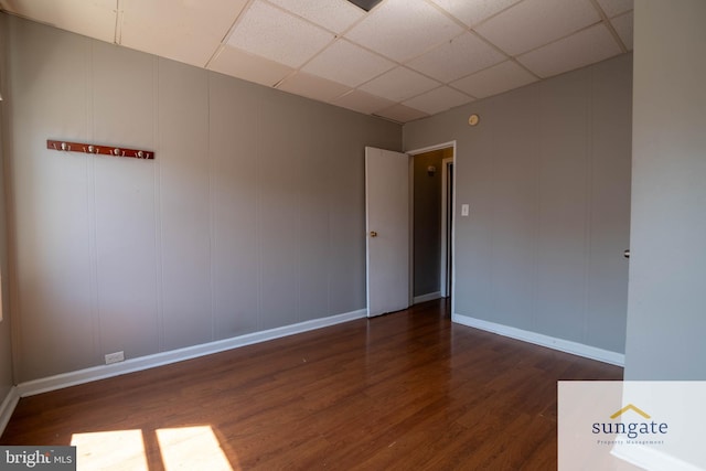 1210 Sargeant St, Baltimore, MD 21223 - empty room with dark wood-style floors, a decorative wall, and a drop ceiling