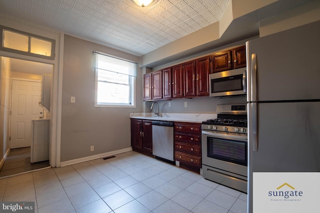 1210 Sargeant St, Baltimore, MD 21223 - kitchen featuring appliances with stainless steel finishes, light countertops, dark brown cabinets, an ornate ceiling, and light tile patterned floors
