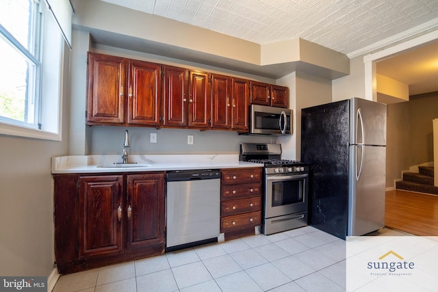 1210 Sargeant St, Baltimore, MD 21223 - kitchen with appliances with stainless steel finishes, light countertops, light tile patterned floors, and an ornate ceiling